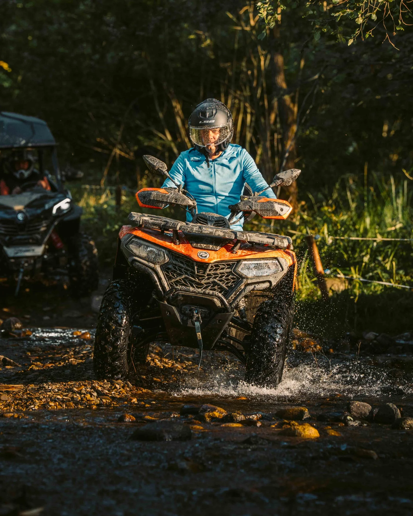 ZDJ-02140 – pomarańczowy quad z kierowcą przejeżdżający przez wodę, buggy w tle