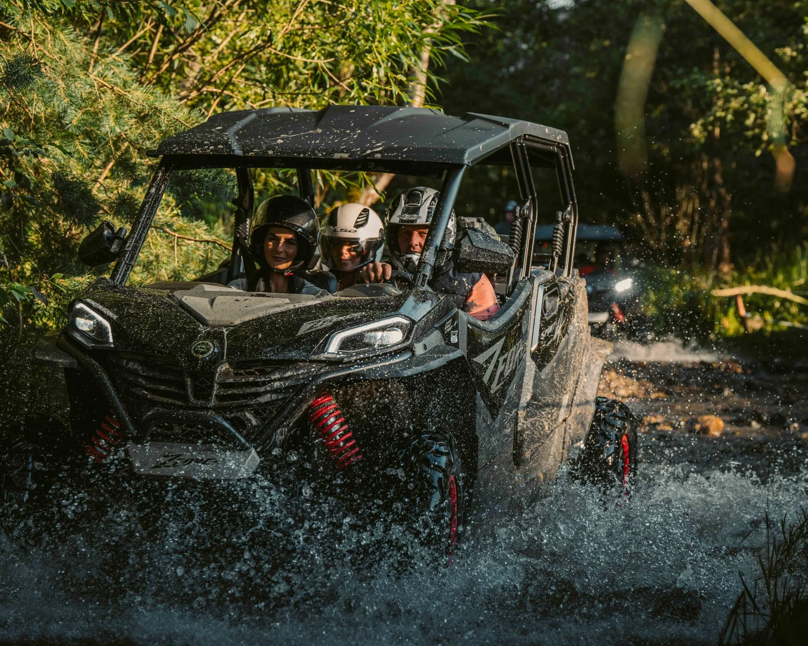 ZDJ-02169 – rodzinne buggy z trzema osobami dynamicznie przejeżdżające przez leśny potok