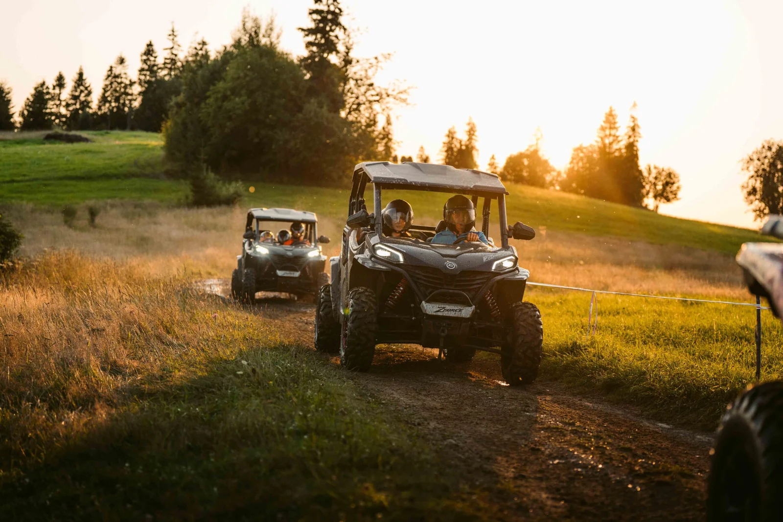 ZDJ-02643 – dwa buggy UTV jadące polną trasą podczas zachodu słońca